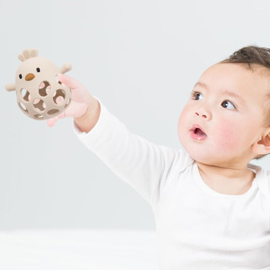 anneau de dentition bebe tenu par bebe