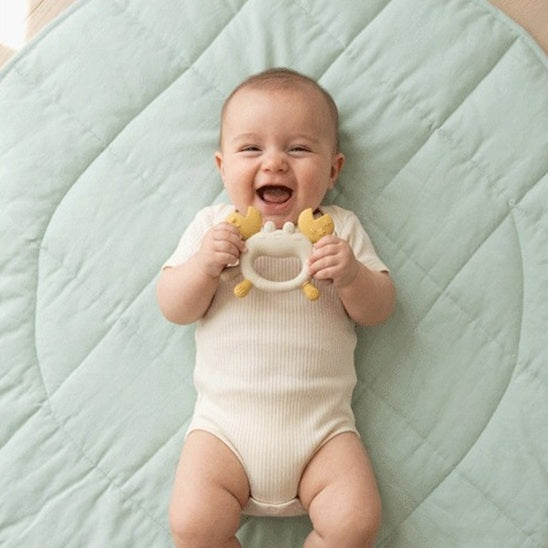 bébé allonge dos tient mains anneau-dentition bébé crabe blanc