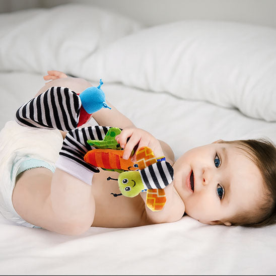 bebe allonge joue hochet bebe main touche pieds