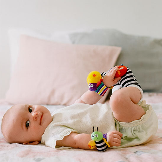 bebe allonge sourit leve pieds avec hochet bebe