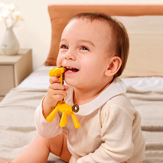 bebe assis mord anneau de dentition girafe jaune