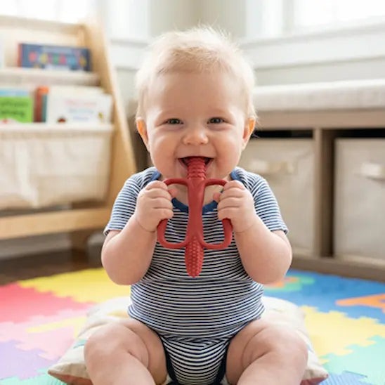 bébé assis tapis tient deux mains anneau de dentition bébé