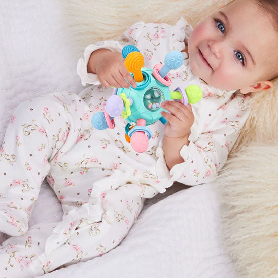 bebe fille allonge dos tient hochet bebe dans mains