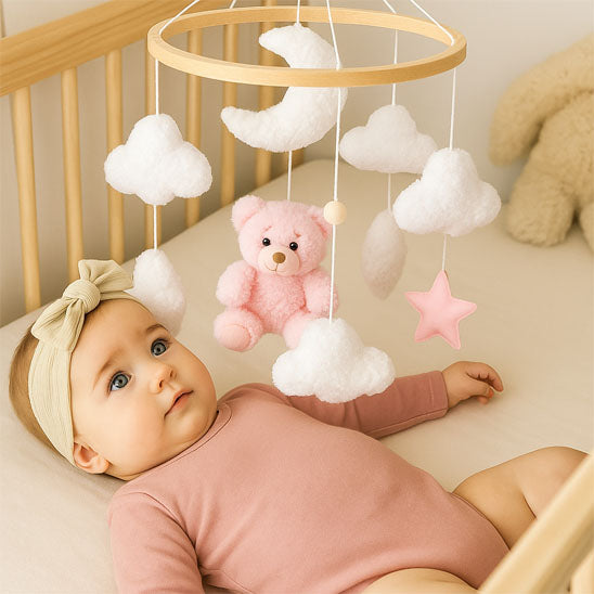 bebe fille captivee par mobile bebe ourson