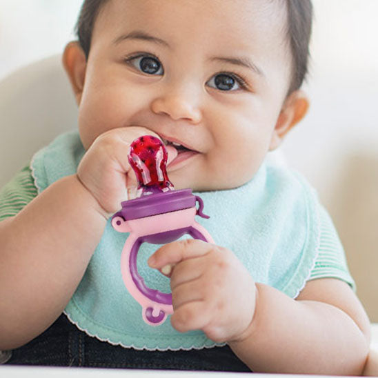 bebe tient grignoteuse bebe avec main droite