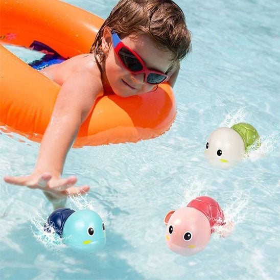 fille dans bouee flotte joue jouet de bain tortue