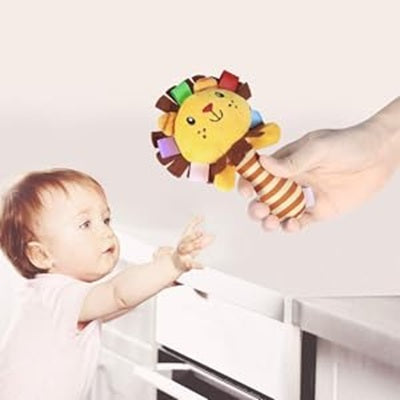 maman tient hochet bebe lion bebe tend main