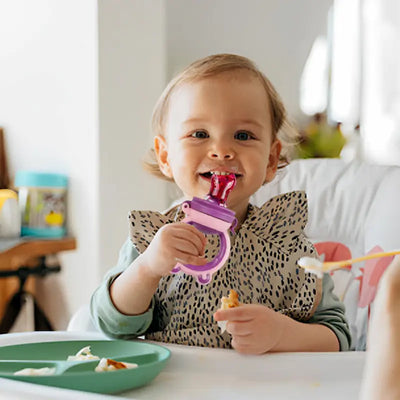 bébé tient grignoteuse bébé et mord tétine pleine aliments solides