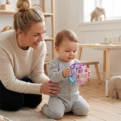 bébé à genoux avec maman tient balle sensorielle bebe