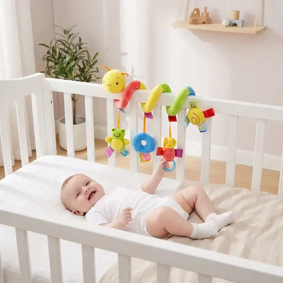 bébé allongé berceau tient hochet chenille colorée