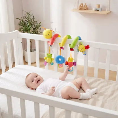 bébé allongé berceau tient hochet chenille colorée