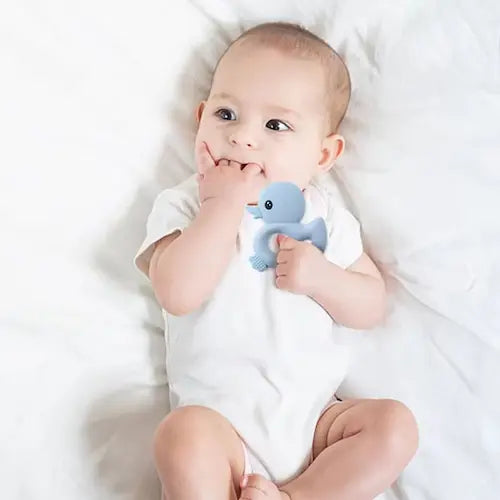 bébé allongé doigt bouche tient anneau dentition bebe carnard bleu