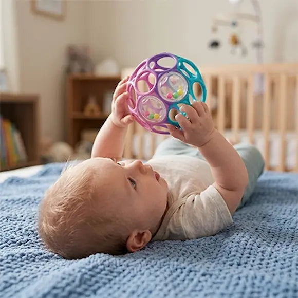 bébé allonge lit tient balle sensorielle bebe