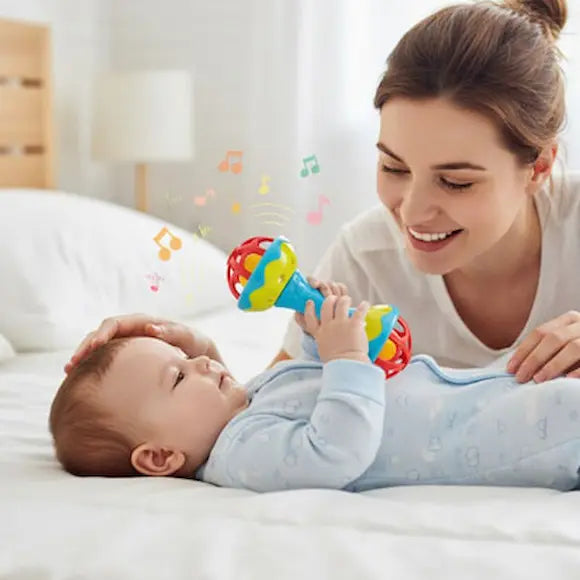bébé allongé lit tient hochet bebe maman caresse tête bébé