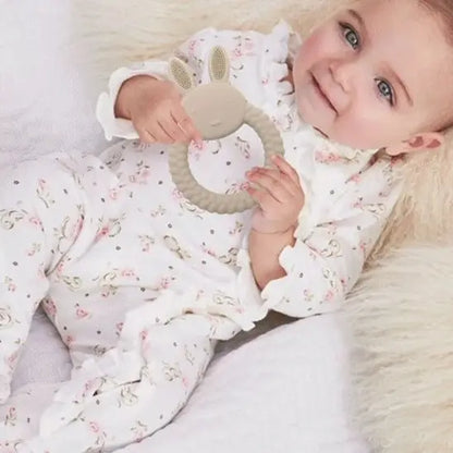 bébé allongé mains anneau de dentition lapin blanc