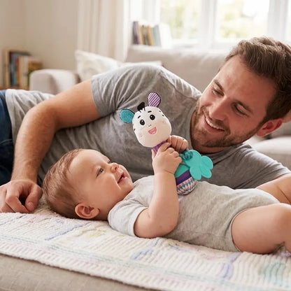 bébé allongé près papa allongé tient hochet bébé zèbre
