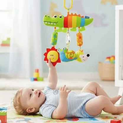 bébé allongé tapis tient éléments suspendus hochet bebe crocodile