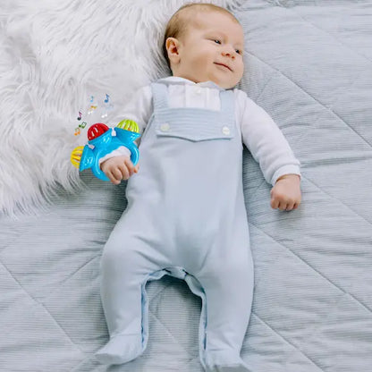 bébé allongé tient main hochet bébé bleu