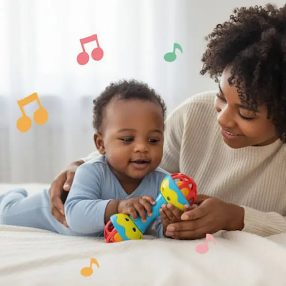 bébé allongé ventre lit tient hochet bebe maman surveille