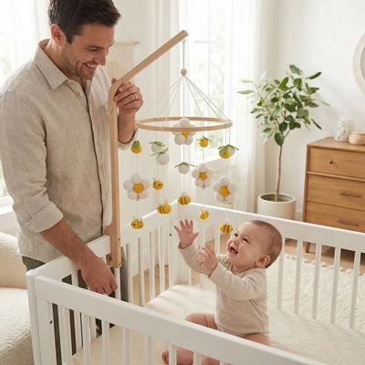bebe assis berceau essaie toucher mobile bebe papa tient support