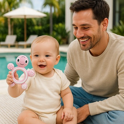 bebe assis bord piscine tient anneau-dentition bebe papa sourit