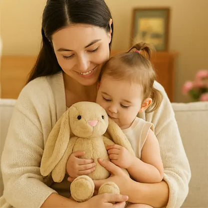 bébé assis bras maman tient peluche bebe lapin