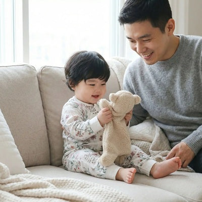 bebe assis canape joue doudou naissance agneau papa regarde sourit