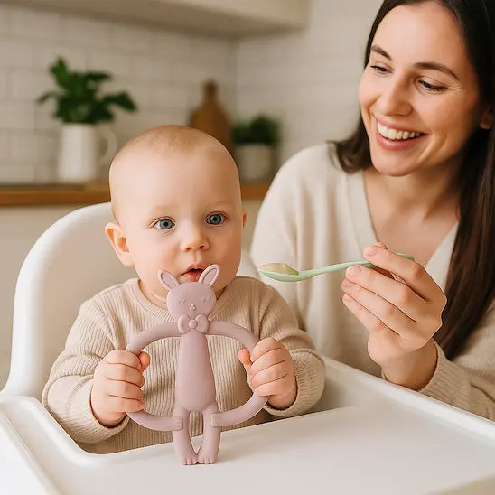 bébé assis chaise haute tient anneau de dentition bébé