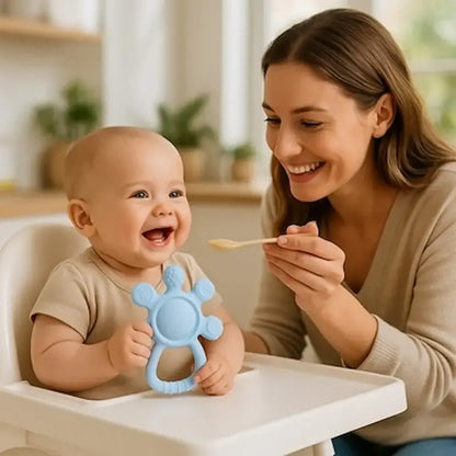 bébé assis chaise haute tient anneau de dentition maman repas