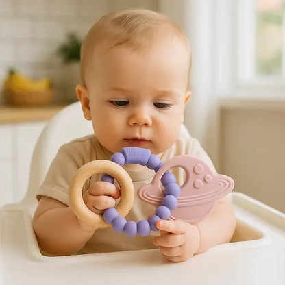 bébé assis chaise haute tient anneau dentition bébé