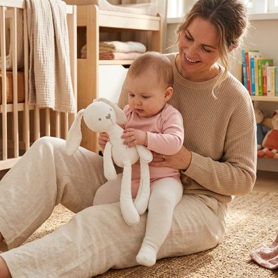 bebe assis cuisse maman assise tapis tient doudou lapin blanc