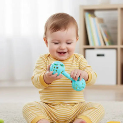 bébé assis joue joyeusement avec hochet bebe