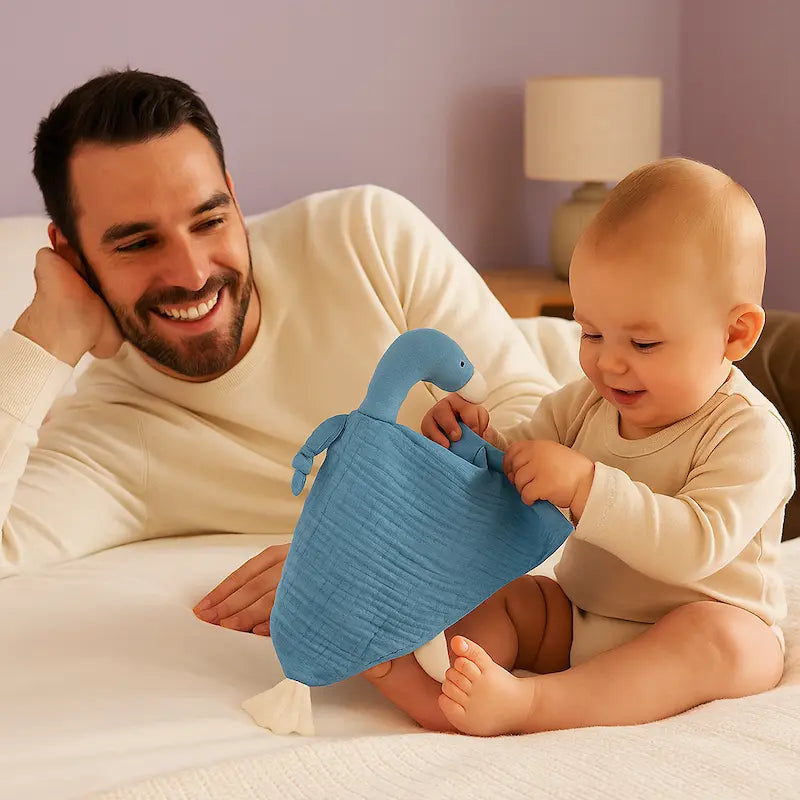 bébé assis lit tient doudou bébé papa allongé sourit