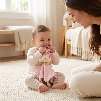 bébé assis mord anneau dentition doudou bebe licorne maman sourit 