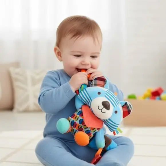 bébé assis mord peluche bebe raton laveur soulage gencives
