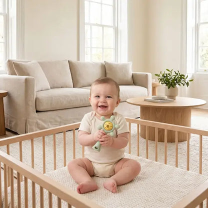 bébé assis parc tient deux mains hochet bebe vert