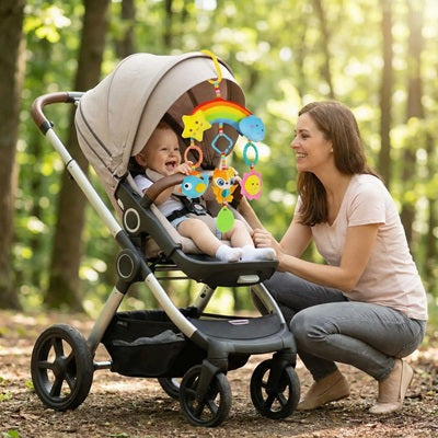 bebe assis poussette joue hochet bebe suspendu maman regarde sourit