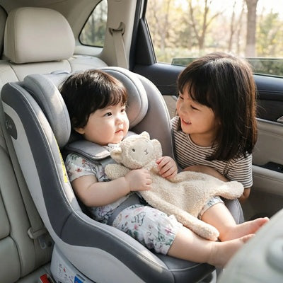 bebe assis siege auto tient doudou naissance agneau soeur sourit