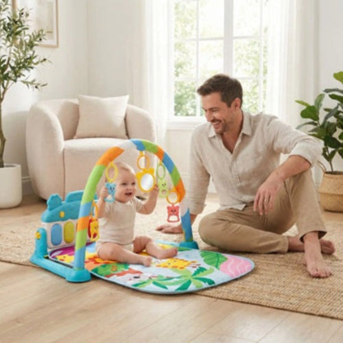 bebe assis tapis d'éveil tient hochets suspendus papa sourit