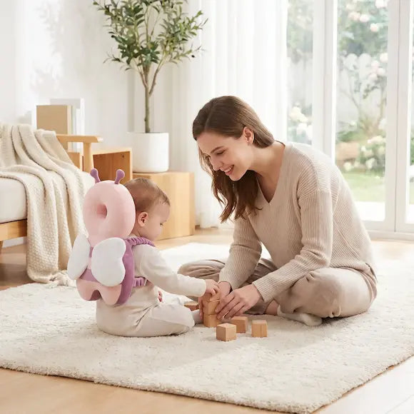 bébé assis tapis porte coussin peluche anti chute maman sourit