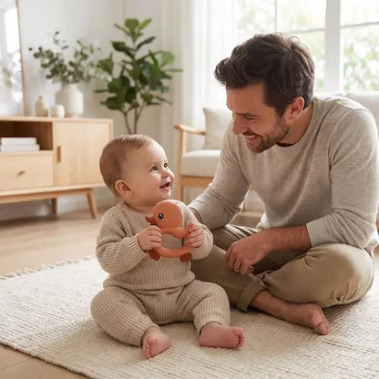bébé assis tapis tient anneau dentition bebe papa regarde bébé