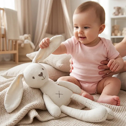 bébé assis tapis tient oreille doudou lapin blanc