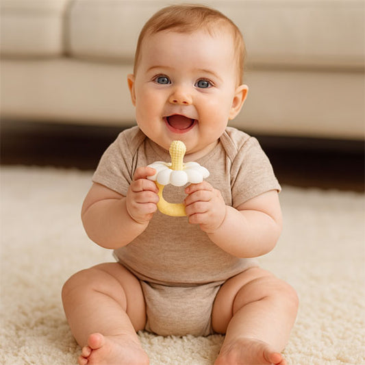 bebe assis tient anneau dentition bebe fleur blanche