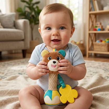 bébé assis tient hochet bébé ours mains