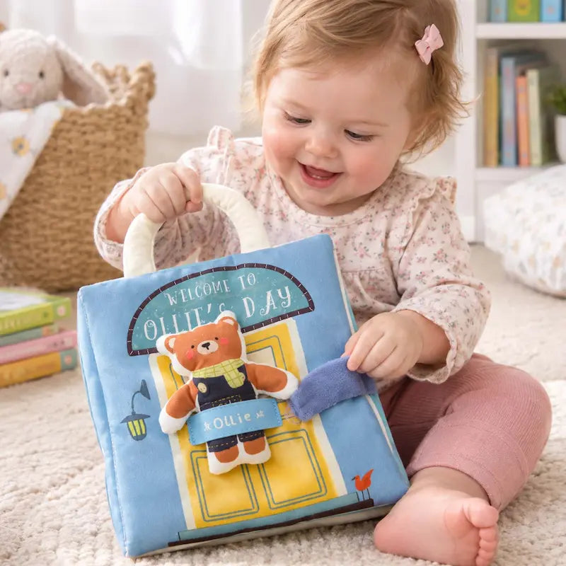 bébé assis tient lance livre bebe en tissus