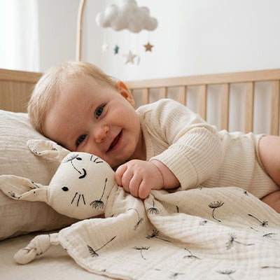 bebe berceau couche cote tient doudou lapin pissenlit