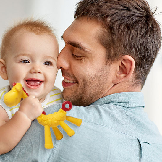 bebe bras papa tient anneau de dentition girafe