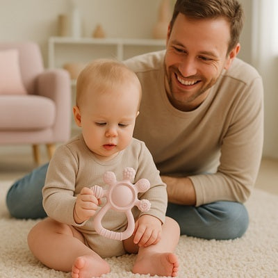 bebe curieux assis moquette tient anneau de dentition papa sourit