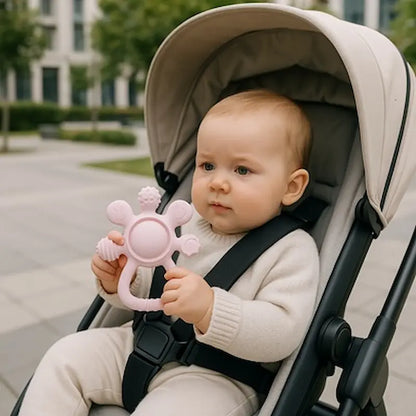 bébé curieux poussette tient anneau de dentition rose
