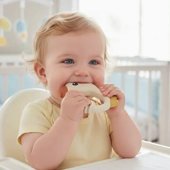 bébé dans chaise haute mordille anneau dentition bebe blanc